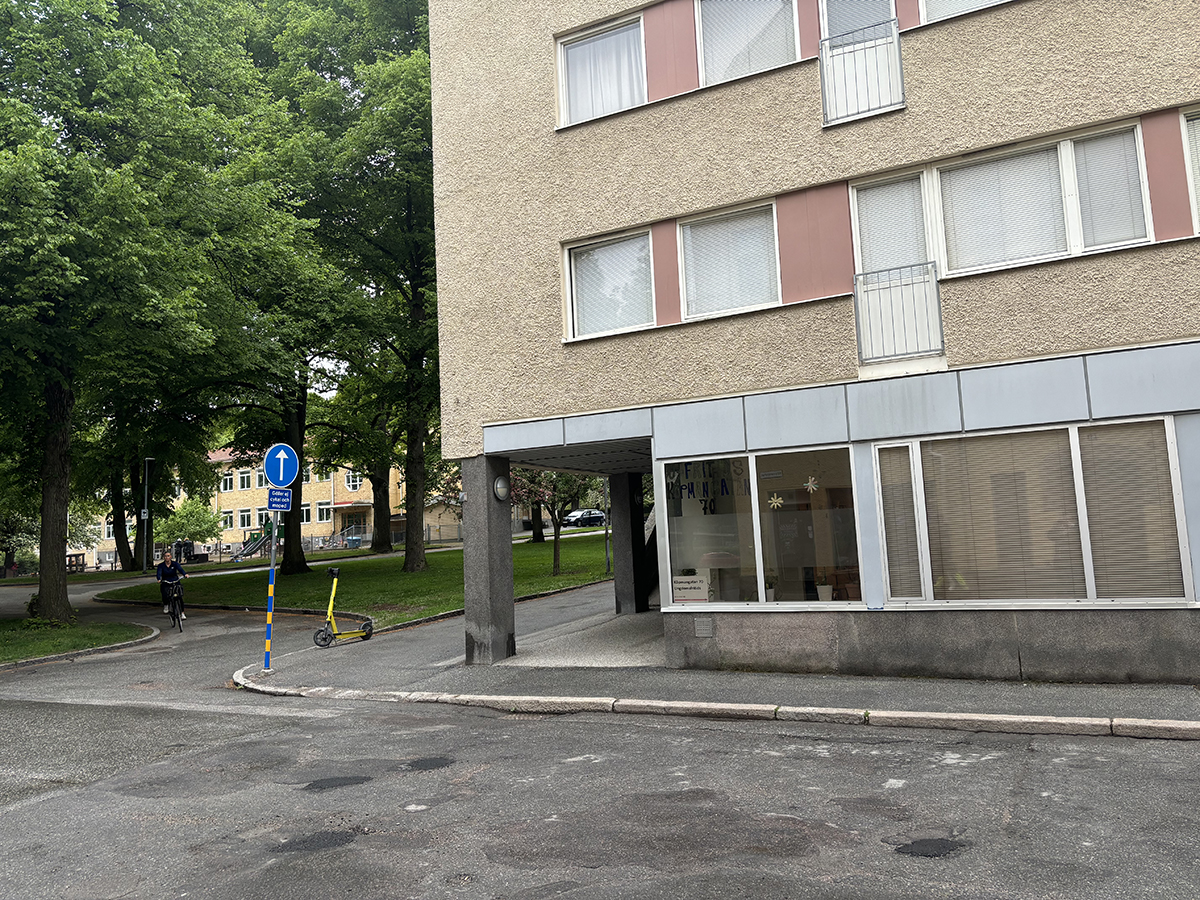 Husgavel med beige putsad fasad och park bredvid.