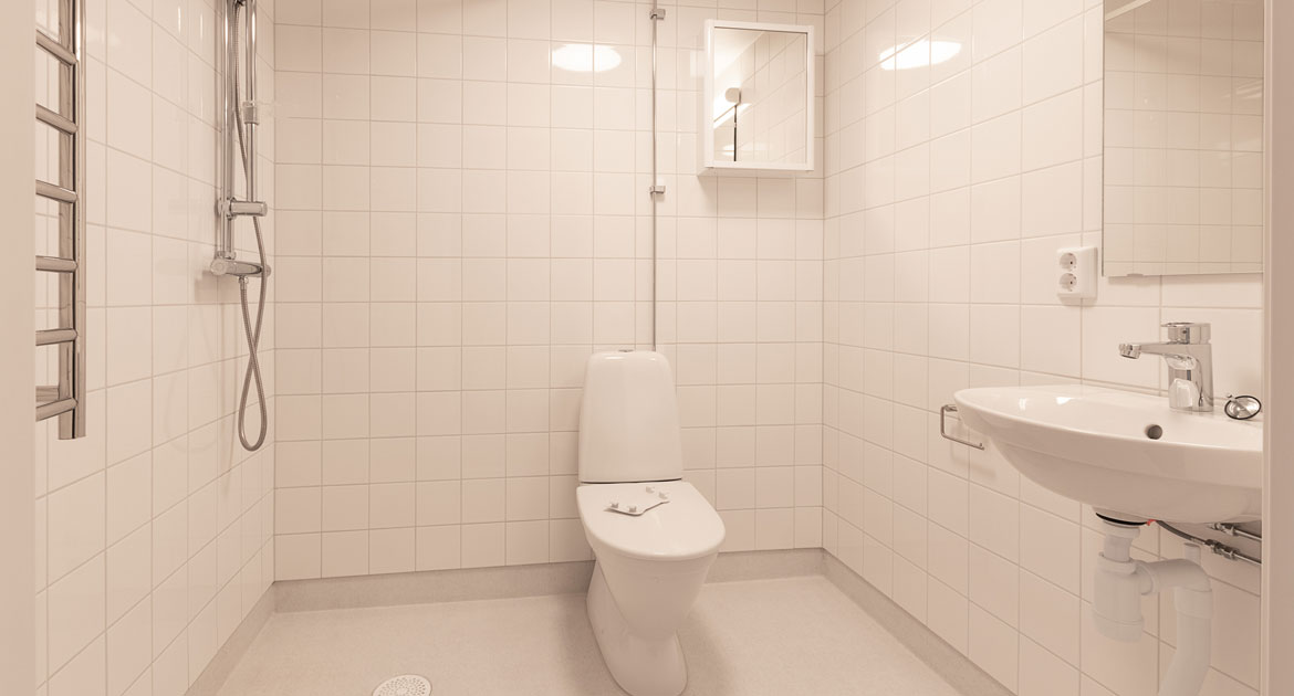 Badrum med kaklade väggar och matta på golvet på Studentgatan.